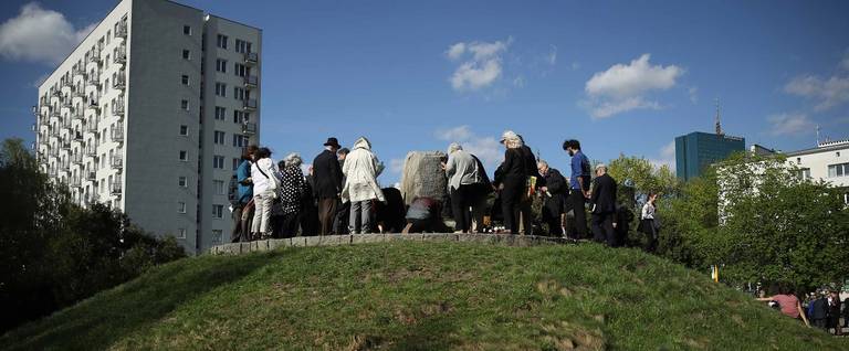 Jewish visitors from the United States from Hashomer Hatzair, the international Jewish Socialist-Zionist secular organization, lay flowers and light candles at a monument on a mound that is a mass grave and the former command bunker of Jewish partisans who fought in the Warsaw Ghetto Uprising on the 75th anniversary of the uprising on April 19, 2018 in Warsaw, Poland. Approximately 75 years ago about a hundred Jewish partisans fought to the death against encircling German troops in the last days of the uprising at the spot at Mila Street 18 that was once deep in the Ghetto and surrounded by dense buildings made of brick. The Warsaw Ghetto was a prison created by the German military during its occupation of Warsaw during World War II. Starting in 1940, 400,000 Jews were confined to a walled-in neighborhood of 3.4 square kilometers under horrific conditions. With assistance from Polish partisans the Jews rose up in armed resistance in 1943 and held off the Germans for several weeks until the Germans annihilated the ghetto, killing 13,000 people. In all 392,000 Jews from the Warsaw ghetto were killed, most of them after deportation to the Treblinka death camp. (