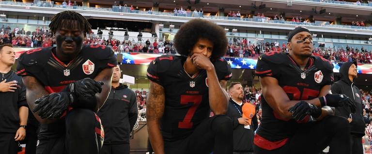 Eli Harold #58, Colin Kaepernick #7, and Eric Reid #35 of the San Francisco 49ers kneel in protest during the national anthem prior to their NFL game against the Arizona Cardinals at Levi's Stadium in Santa Clara, California, October 6, 2016. 