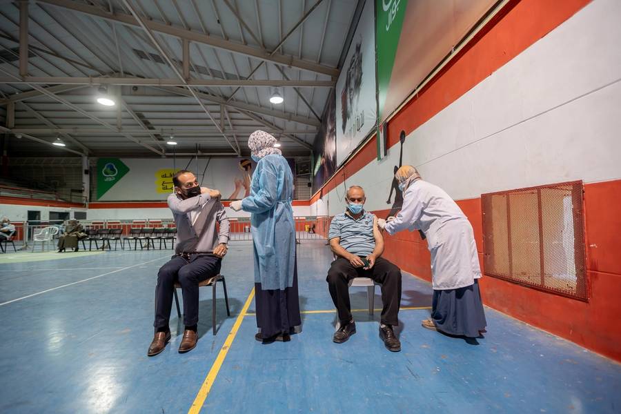 Palestinian men receive the Chinese Sinopharm COVID-19 vaccine at a medical center in Bethlehem on April 29, 2021
