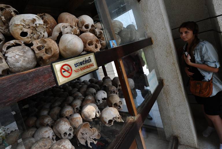 A foreign tourist looks at skulls of Khmer Rouge's victims displayed in a memorial at the site of the former killing field at Choeung Ek in the outskirts of Phnom Penh, Cambodia, on Feb. 2, 2012.(HOANG DINH NAM/AFP/Getty Images)