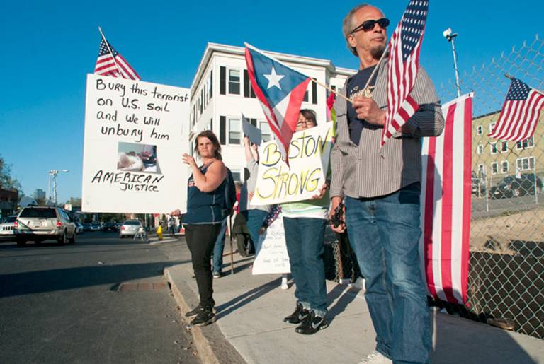 From left, on May 5, 2013, Lisa Taurasi, Lucy Rodriguez and Luis Barbosa, all of Worcester, Mass., protest across the street from Graham Putnam & Mahoney Funeral Parlors in Worcester, Mass., where the body of Boston Marathon bombing suspect Tamerlan Tsarnaev was being held.(Betty Jenewin/Worcester Telegram & Gazette/AP)