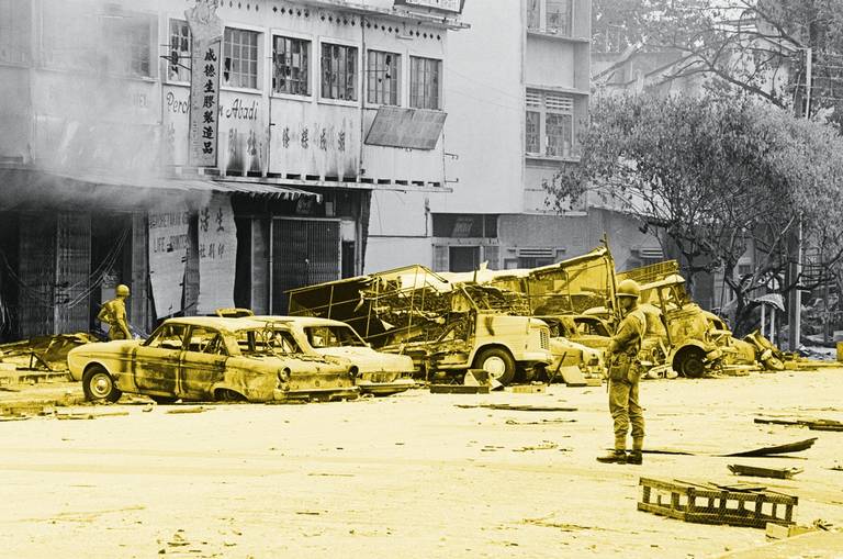 Troops of the Malay Royal Regiment patrol damaged and littered streets of the Chinatown area in Kuala Lumpur following days of racial rioting between Chinese and Malay mobs that left 100 people dead, May 17, 1969