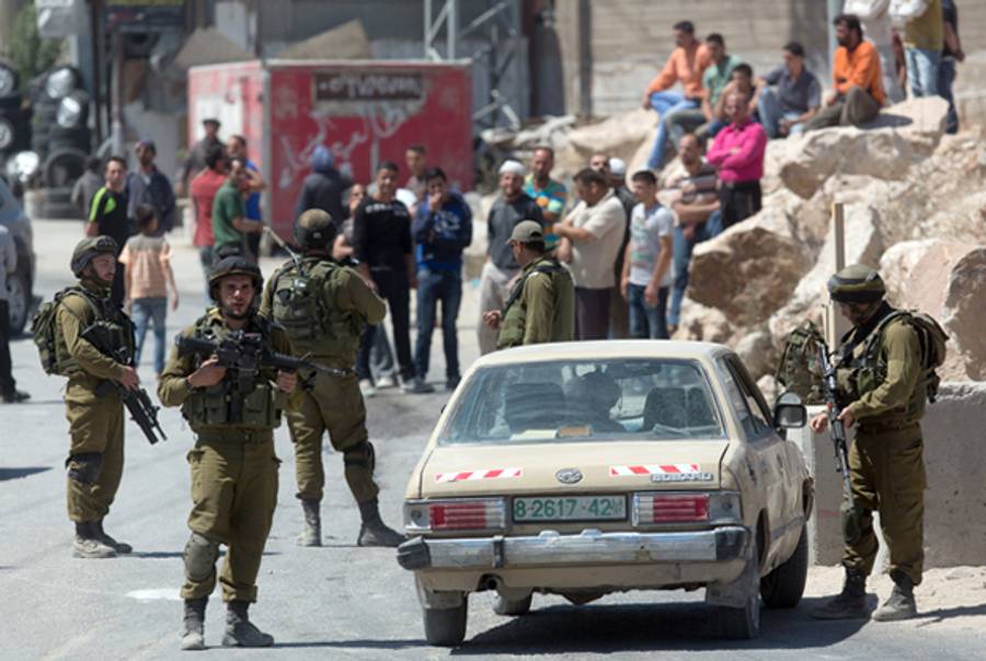 Israeli soldiers man a checkpoint in the West Bank town of Hebron on June 15, 2014, as Israel broadened the search for three teenagers believed kidnapped by militants and imposed a tight closure of the town. (MENAHEM KAHANA/AFP/Getty Images)