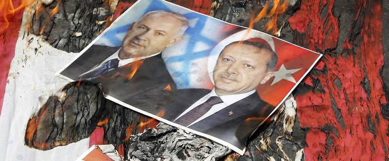 Portraits of Israeli Prime Minister Benjamin Netanyahu and Turkish President Recep Tayyip Erdogan lie on a US flag in flames during a parade marking al-Quds (Jerusalem) Day in Tehran on July 1, 2016. Tens of thousands joined pro-Palestinian rallies in Tehran, as the annual Quds Day protests take on broader meaning for a region mired in bitter disputes and war. 