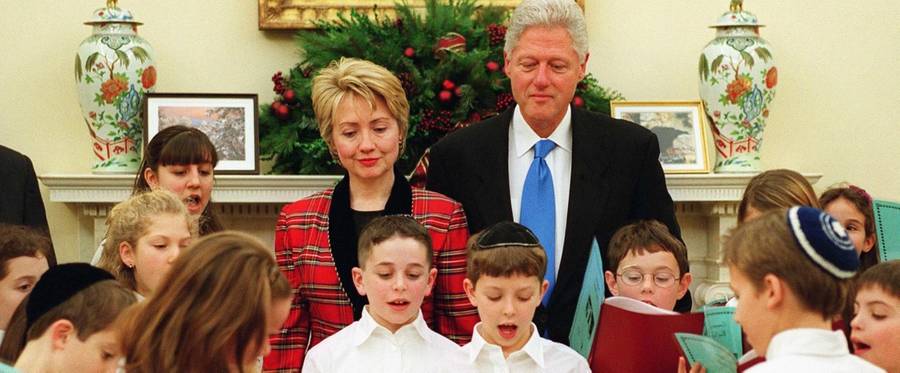 President Bill Clinton and First Lady Hillary Clinton watch as children from B'nai Tzedek temple in Potomac, MD, sing and light the menorah as part of Hanukkah festivities at the White House on December 21, 2000. 