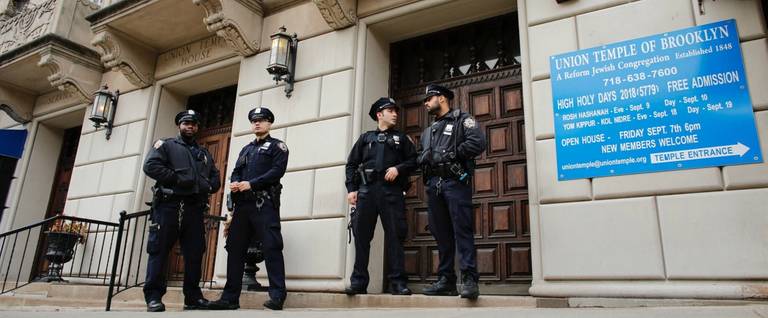 NYPD officers stand guard at the door of the Union Temple of Brooklyn on Nov. 2, 2018. New York police were investigating anti-Semitic graffiti found inside the Brooklyn synagogue that forced the cancellation of a political event less than a week after Pittsburgh's Tree of Life synagogue massacre, the worst anti-Semitic attack in modern U.S. history.