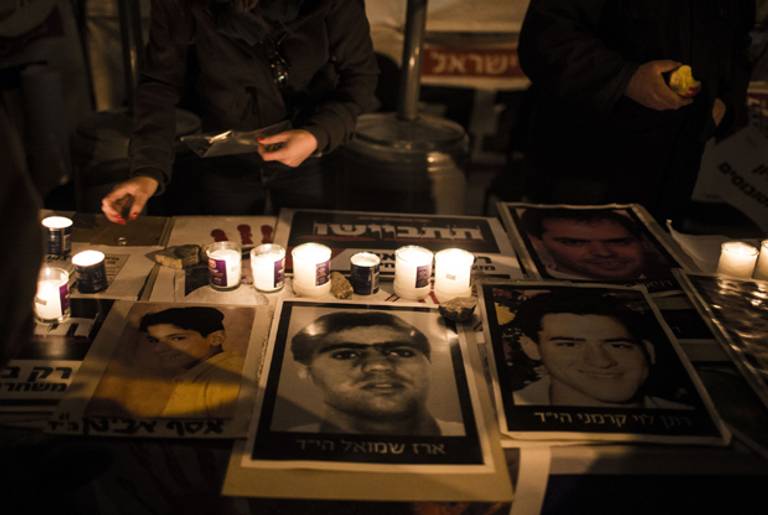 Portraits of victims of terror seen on a table before a protest of the Palestinian prisoners release on December 30, 2013 in Jerusalem, Israel. (Ilia Yefimovich/Getty Images)