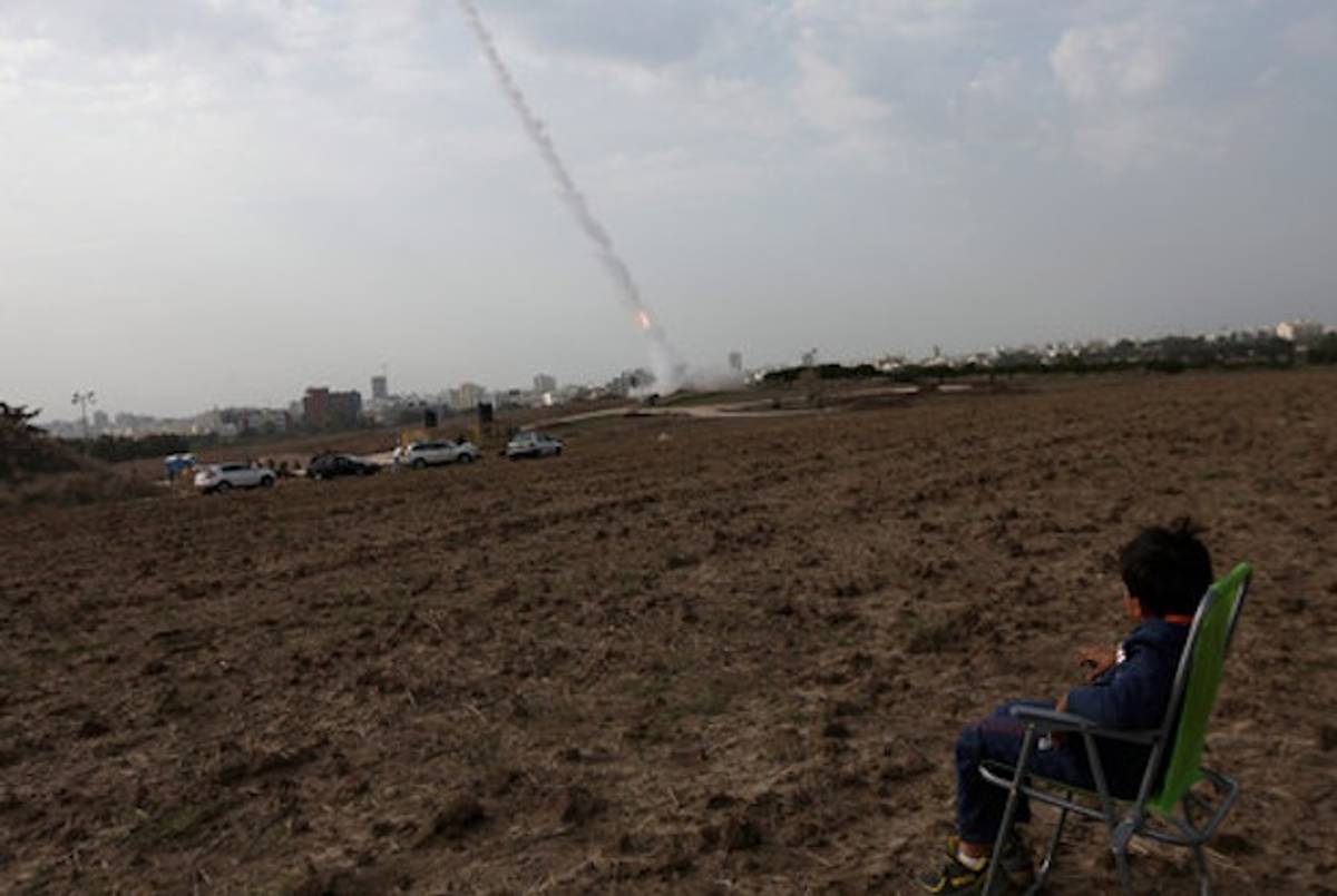 A child watches from a field near Ashdod, Israel, as a missile is fired to intercept an incoming Palestinian rocket. (NYT)