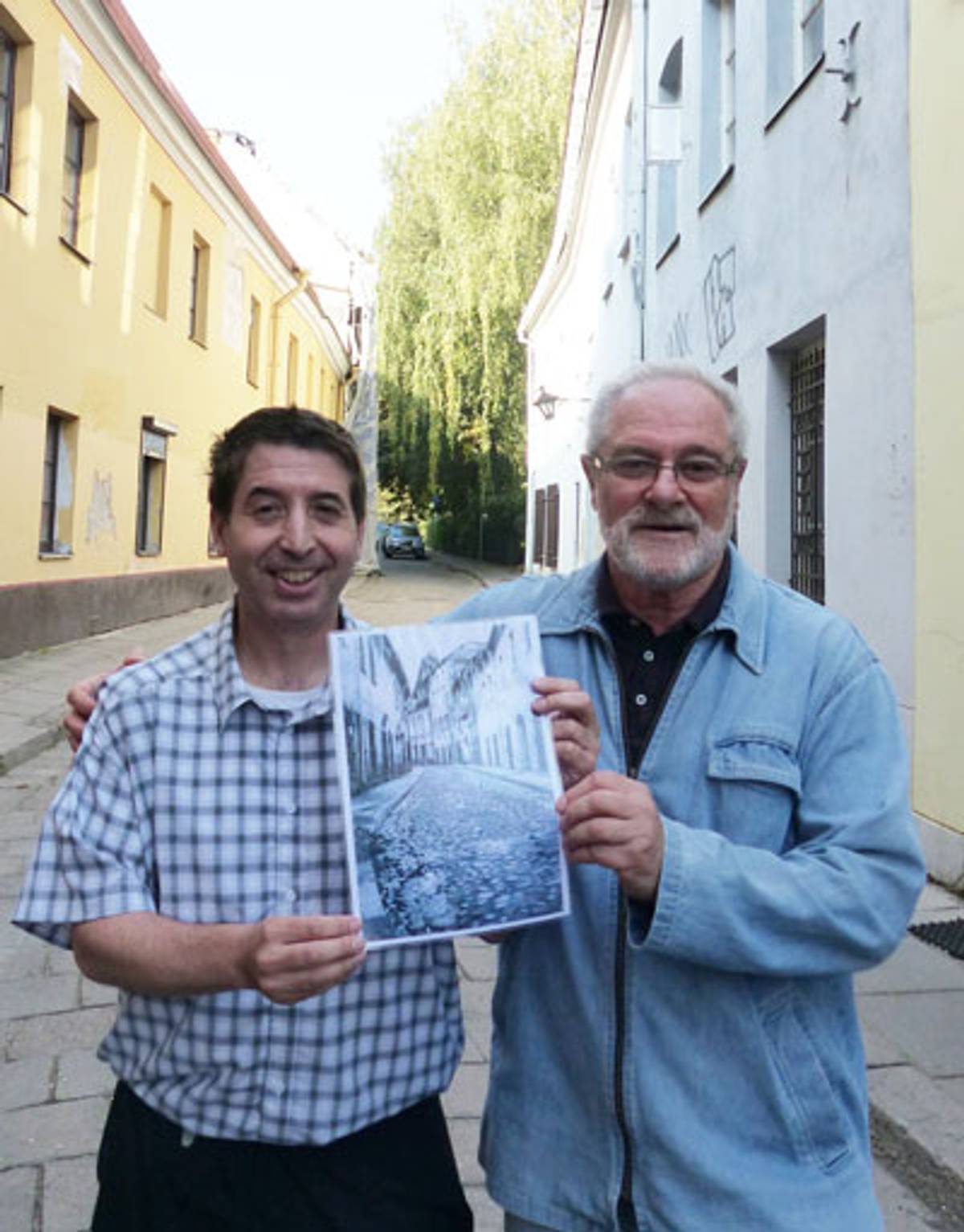 The author with his Vilnius tour guide, Yulik Gurvitch. They’re holding a printout of a scan from Moshe’s book, and the image depicts the street they’re on.  (Photo: Liz Landau)