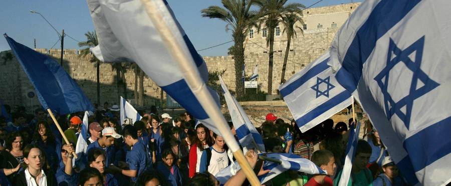 Israelis march with their national flag next to Jerusalem's Old City walls during the Jerusalem Day parade, June 5, 2005.