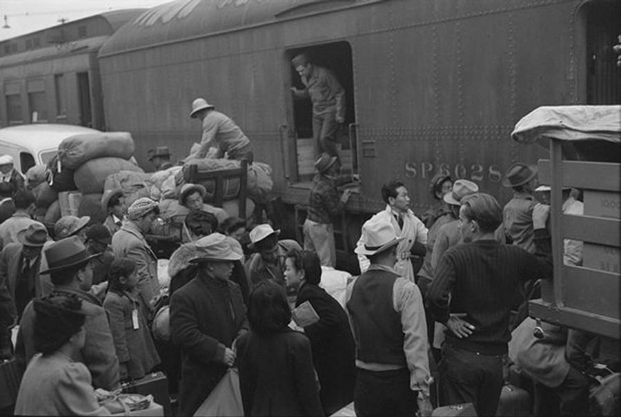 The evacuation of the Japanese Americans from West Coast areas under U.S. Army war emergency order. Japanese Americans going to camp at Owens Valley gather around a baggage car at the old Santa Fe Station in Los Angeles