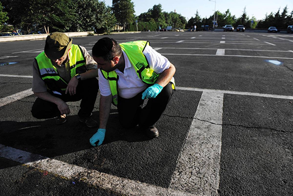 Members of the Israeli rescue and recovery squad collect evidence during investigations at the Airport in Burgas on July 19, 2012, site of a suicide blast targeting Israelis the day earlier. (STR/AFP/GettyImages)