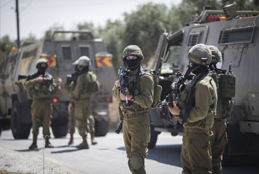 An Israeli soldier conducts a search mission during the sixth day into the search of three missing teenagers June 18, 2014 in Hebron, West Bank. (Ilia Yefimovich/Getty Images)