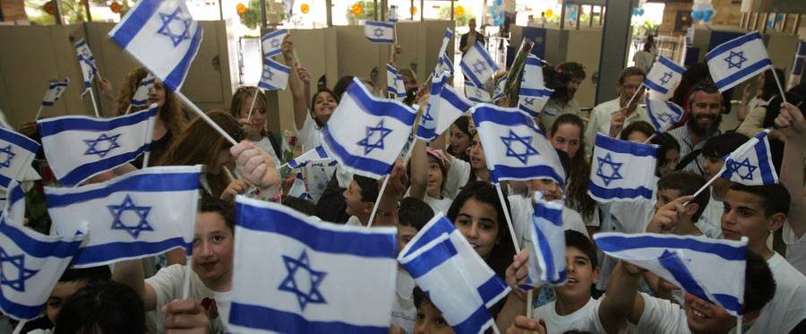 Israeli children wave their national flag as they welcome immigrants to Israel's Ben Gurion airport on May 5, 2008. Four hundred immigrants from 23 countries arrived in Israel today as part of Israel's 60th anniversary celebrations.