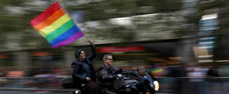 Parade participants wave a pride flag as they ride with the group Dykes on Bikes during the 2016 San Francisco Pride Parade, June 26, 2016.