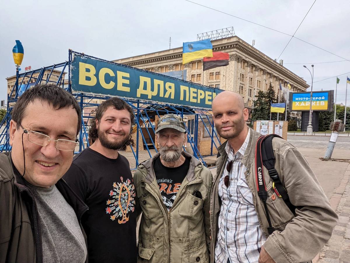 From left: Boris Redin, the volunteer; Zakharov; Bruce (no last name available), a 72-year-old Canadian volunteer; and the French photojournalist Jérôme Barbosa, in late May in Kharkiv's Liberty Square, which housed the Kharkiv regional administration and was significantly damaged early in the war by Russian rockets, one of which is still visible to the right of Barbosa. The banner says 'Everything for Victory' in Ukrainian