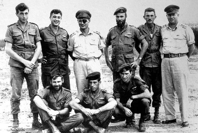Members of 890th Paratroop Battalion in November 1955. Meir Har-Zion is standing on the far left, with Ariel Sharon and Moshe Dayan next to him. (Wikimedia)