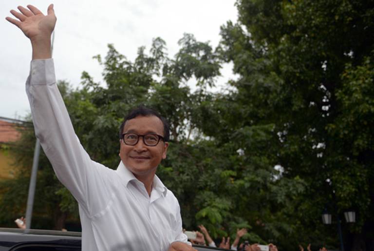 Sam Rainsy, leader of the opposition Cambodia National Rescue Party (CNRP), waves to supporters during a religious ceremony in Phnom Penh on July 30, 2013.(TANG CHHIN SOTHY/AFP/Getty Images)