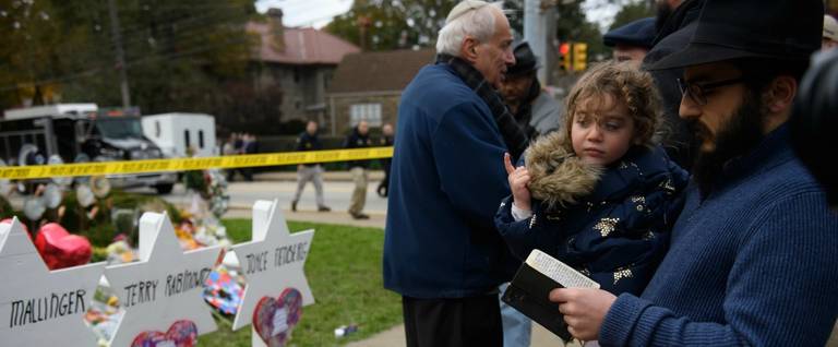 Mourners pause in front of a memorial for victims of the mass shooting that killed 11 people and wounded six at the Tree Of Life synagogue on Oct. 29, 2018, in Pittsburgh.