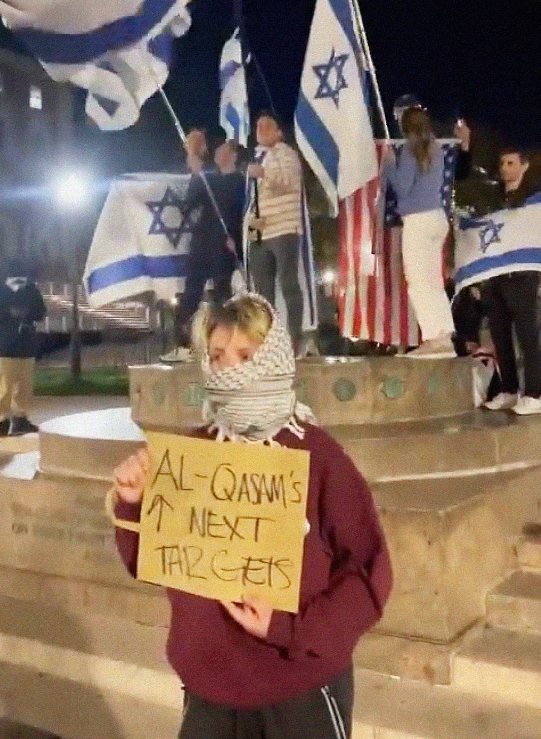 An anti-Israel demonstrator at Columbia University holds a sign reading ‘Al-Qasam’s next targets,’ with an arrow pointing at Jewish students
