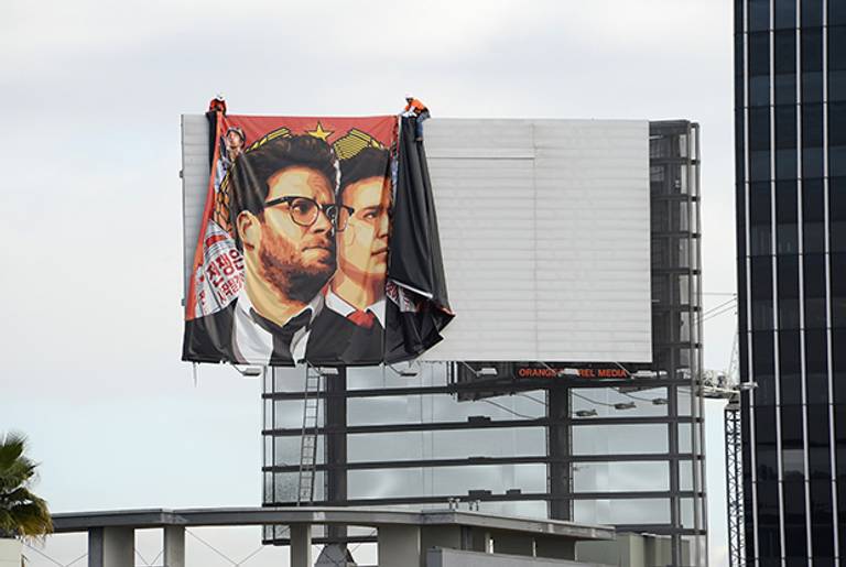 Workers remove a poster-banner for 'The Interview' from a billboard in Hollywood, California, December 18, 2014 a day after Sony announced it had no choice but to cancel the movie's Christmas release and pull it from theaters due to a credible threat. (ROBYN BECK/AFP/Getty Images)