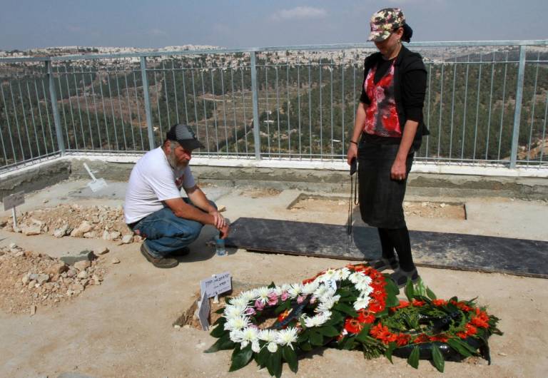 Israelis mourn next to the newly dug graves of Eitam and Na’ama Henkin following their funeral in Jerusalem’s cemetery on Oct. 2, 2015. The couple were killed by suspected Palestinian gunmen the previous night as they were driving through the occupied West Bank.
