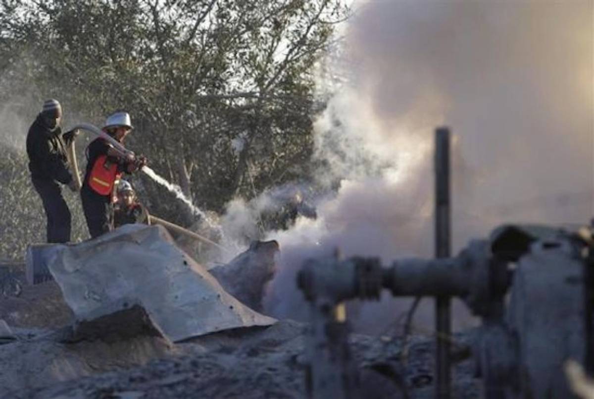 A member of Palestinian civil defense extinguishes a fire at a Hamas training camp after it was hit by an Israeli air strike in Khan Younis in the southern Gaza Strip.(Reuters)