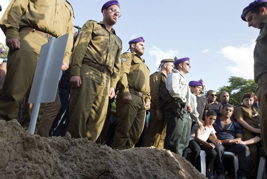 Israeli soldiers, friends, and family gather at the grave of Staff Sergeant Gal Kobi, 20, during his funeral in the military cemetery in Haifa on September 23, 2013, after he was shot in the neck near a checkpoint in Hebron.(JACK GUEZ/AFP/Getty Images)