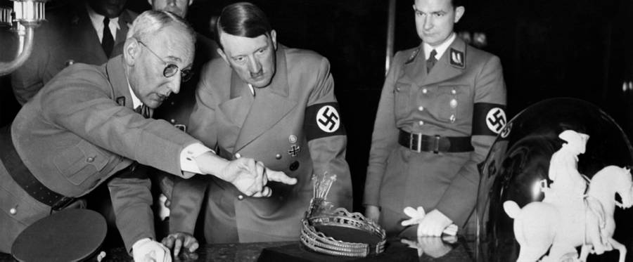 An undated and picture shows German Nazi chancellor Adolf Hitler looking at a tiara and a sculpture of Napoleon Bonaparte during his visit of an art exhibition in an unknown location. Rudolf Hess stands in the background.