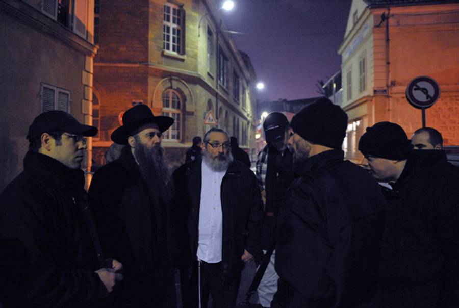 Rabbi Belinow Mendel (second from left) speaks with policemen next to his synagogue in Saint-Denis, outside Paris, on Jan. 12, 2009, after a few people lit several gas cylinders in front of the synagogue.(Bertrand Langlois/AFP/Getty Images)