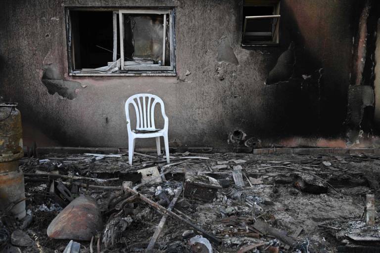 A chair sits outside a burnt house in Kibbutz Be'eri after the October 7 attack by Hamas militants