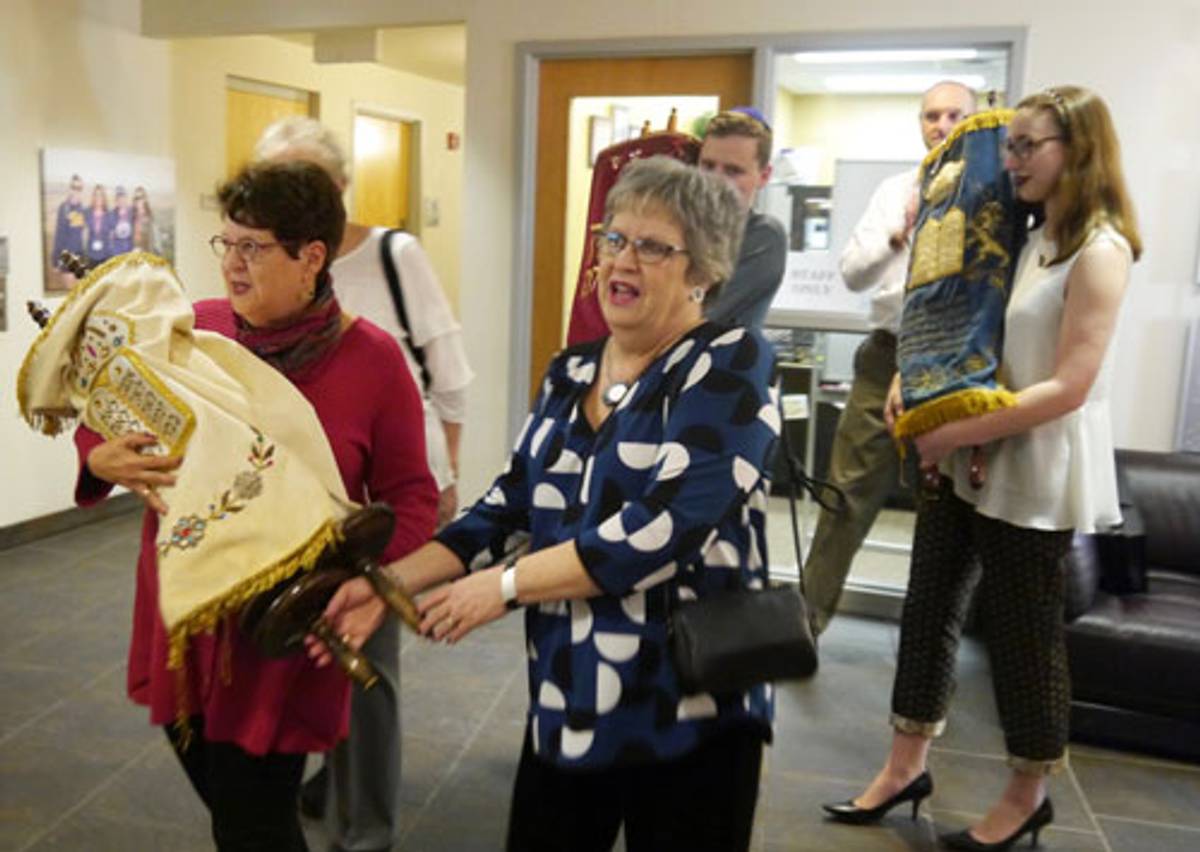 Deena Mirow Epstein and her sister Ina Silver parade the Temple Hadar Israel Torah into Pittsburgh’s Hillel Jewish University Center, with students following them. (Photo: Alanna Cooper)