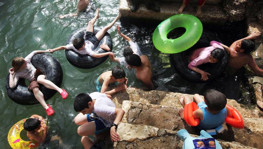 Israeli children enjoy the spring water of Nahal Prat