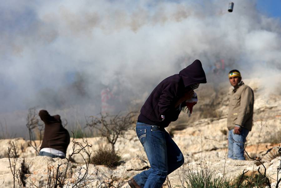 Protesters run from a tear gas cannister in the day after Tamimi's death.(Abbas Momani/AFP/Getty Images)