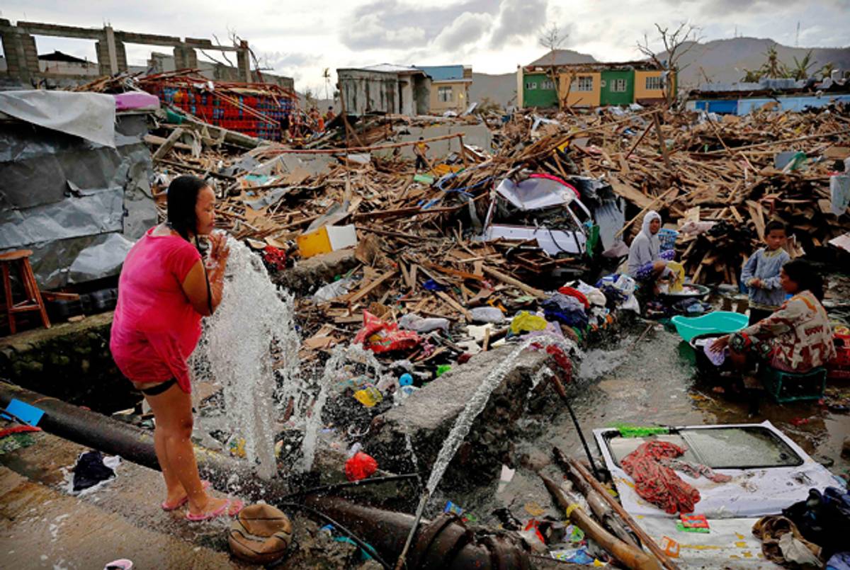 A woman washes amid scenes of devastation in the aftermath of Typhoon Haiyan on November 13, 2013 in Tacloban, Leyte, Philippines. ( Kevin Frayer/Getty Images)