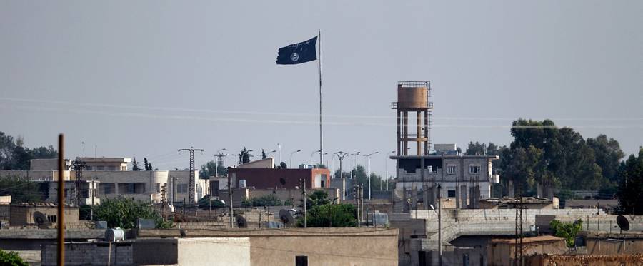 An Islamic State flag flies in the northern Syrian town of Tel Abyad as it is pictured from the Turkish border town of Akcakale, in Sanliurfa province of Turkey, June 15, 2015. 