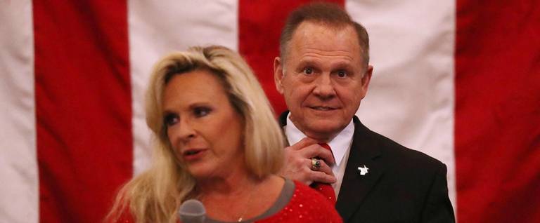 Republican Senatorial candidate Roy Moore stands behind his wife Kayla Moore as she speaks during a campaign event at Jordan's Activity Barn on December 11, 2017 in Midland City, Alabama.