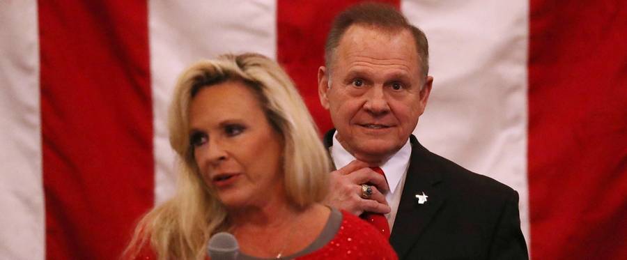 Republican Senatorial candidate Roy Moore stands behind his wife Kayla Moore as she speaks during a campaign event at Jordan's Activity Barn on December 11, 2017 in Midland City, Alabama.