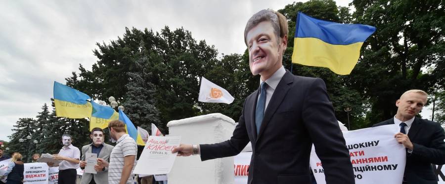 A protester wears a mask of Ukrainian President Petro Poroshenko in Kiev, June 17, 2015. 