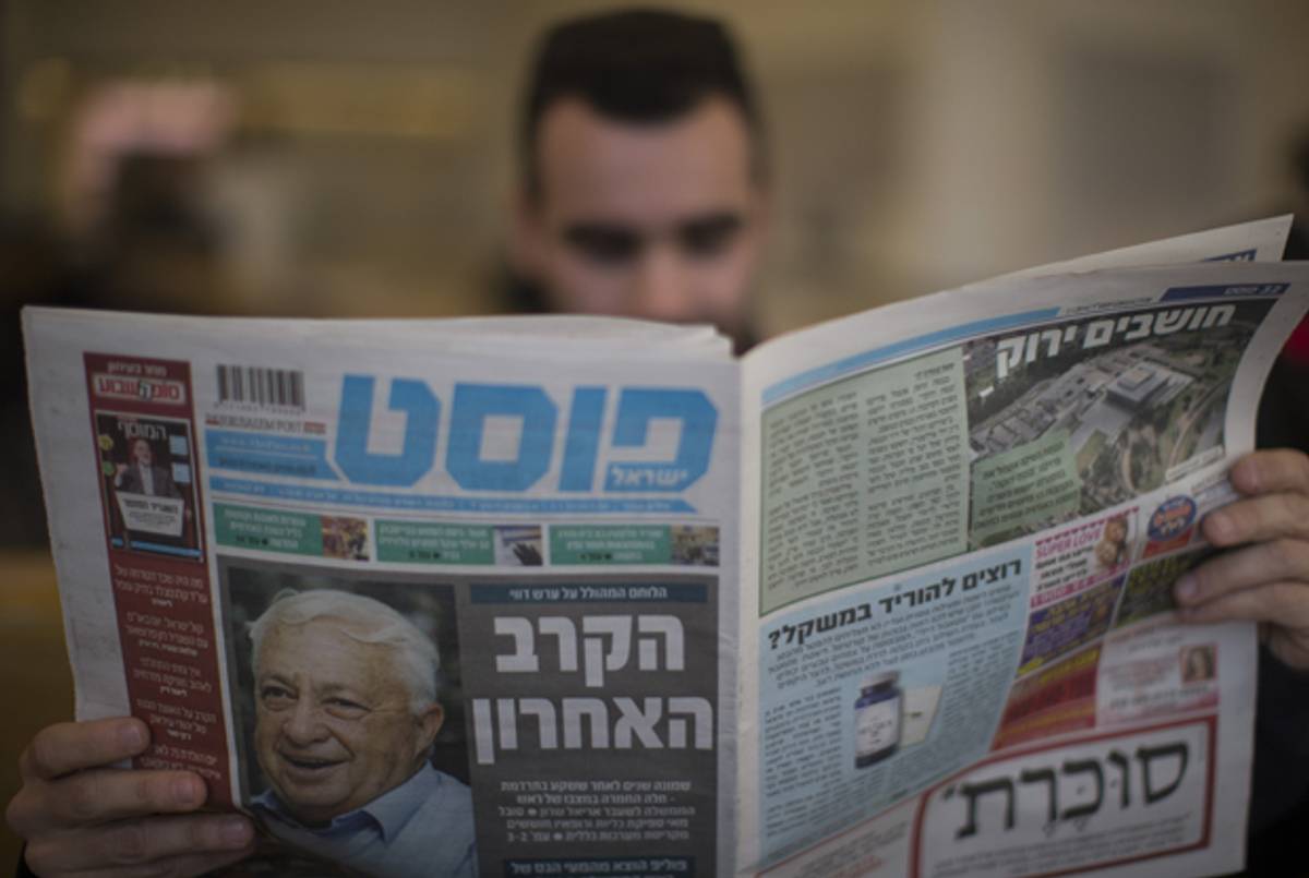 A journalist reads a newspaper the Tel Hashomer hospital as he waits for an update on Former Prime Minister Ariel Sharon's condition on January 2, 2014 near Tel Aviv, Israel. (Uriel Sinai/Getty Images)