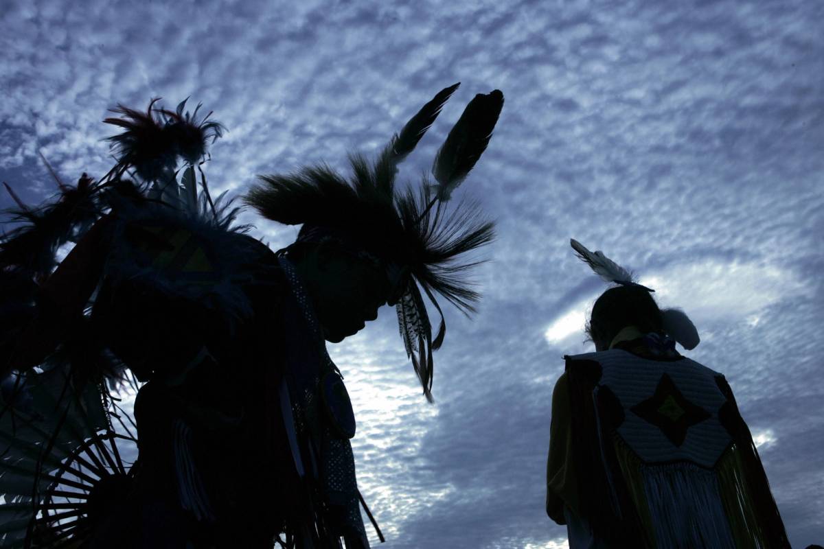 Harrison Revels (left) and his cousin Courtney Baxter, members of the Lumbee Tribe in North Carolina, wait for a tribal dance on the National Mall after the grand opening of the Smithsonian's National Museum of the American Indian, 2004