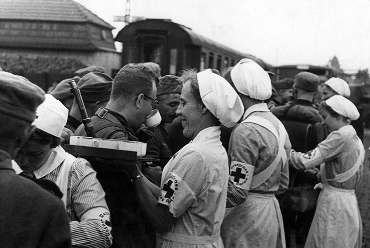 Some Red Cross nurses giving hot beverages to the passing soldiers in a sorting station of the German army in Poland, September 1939.(Mondadori Portfolio/Getty Images)