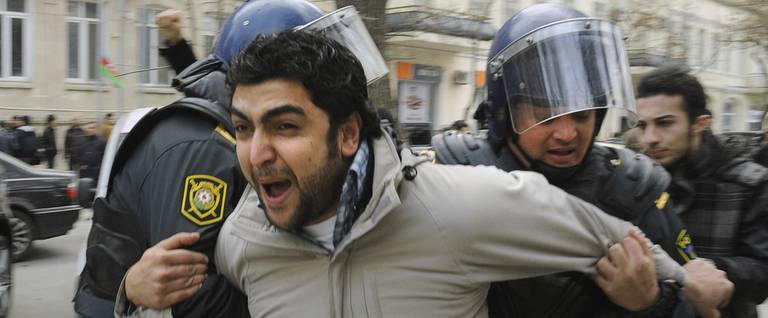 Azeri riot policemen detain a protester in central Baku, January 26, 2013. 