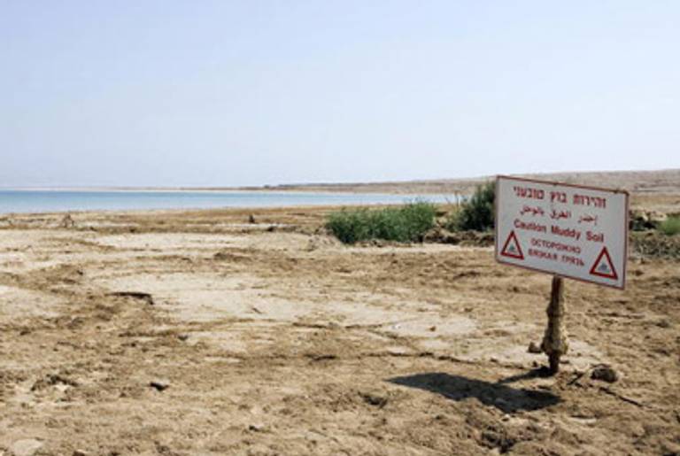 A sign warning of muddy soil is seen near Ein Gedi on the retreating shores of the Dead Sea on September 10, 2008.(JONATHAN NACKSTRAND/AFP/Getty Images.)